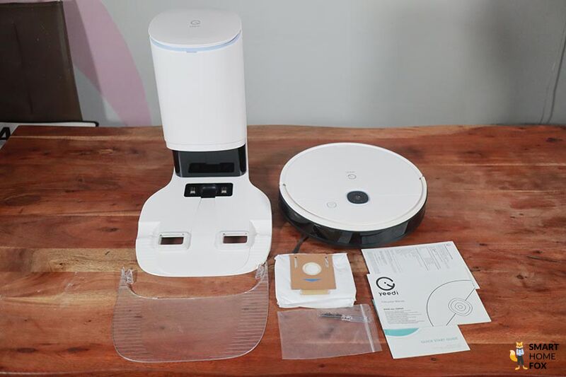 Der gesamte Lieferumfang der Yeedi Vac Station steht nebeneinander auf einem Tisch